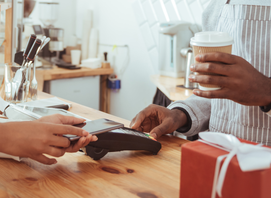 Hands paying for coffee with phone