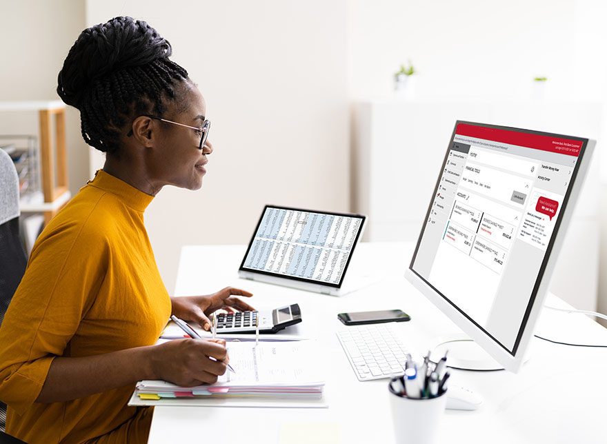 Woman using multiple computers for banking.